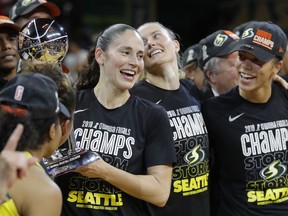 FILE - In this Sept. 18, 2018, file photo, Seattle Storm guard Sue Bird, left, holds the championship trophy with her teammates during after winning Game 3 of the WNBA basketball finals, in Fairfax, Va. The WNBA is nearly doubling its national TV exposure with a multiyear deal with CBS Sports. CBS Sports Network will broadcast 40 WNBA games beginning next month when the season opens. "Sue Bird and the WNBA defending champion Seattle Storm will make six appearances on the CBS Sports Network this season."
