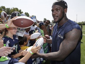 FILE - In this Aug. 6, 2018, file photo, Seattle Seahawks defensive end Frank Clark signs autographs following NFL football training camp, in Renton, Wash. The Kansas City Chiefs have agreed to acquire defensive end Frank Clark from the Seattle Seahawks in exchange for a first-round draft pick this year and a second-round pick in 2020. Almost immediately after word leaked of the trade on Tuesday, April 23, 2019, Clark and the Chiefs worked quickly to reach agreement on a five-year contract worth up to $105 million, according to a person with knowledge of the deal. The person spoke to The Associated Press on the condition of anonymity because the deal had not been announced by either team and was still pending a physical.