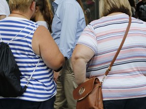 FILE - In this Tuesday, Aug. 16, 2016 file photo, two overweight women tour the World Trade Center in New York. A study published by the journal Cell on Thursday, April 18, 2019 suggests that a genetic test can identify newborns at heightened risk of becoming severely obese by middle age, possibly giving time for interventions designed to head off that fate.