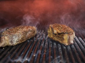 FILE - This Nov. 27, 2018 file photo shows steaks on a grill at a restaurant in New York. The idea behind the low-carb diet is that the body enters a ketogenic, fat-burning state when it runs out of the blood sugar that's fueled by carbs. Still, many nutrition experts say sticking to a low-carb diet is hard, and not everyone is convinced it should be added to the dietary guidelines.