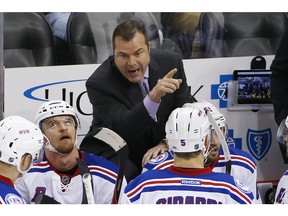 FILE - In this Nov. 2016, file photo, New York Rangers head coach Alain Vigneault, top, gives instructions in the third period of an NHL hockey game against the Pittsburgh Penguins in Pittsburgh. The Philadelphia Flyers have hired Vigneault as head coach. Vigneault has led the Rangers and Vancouver Canucks to the Stanley Cup final and takes over a Flyers team that missed the playoffs for the second time in three seasons.