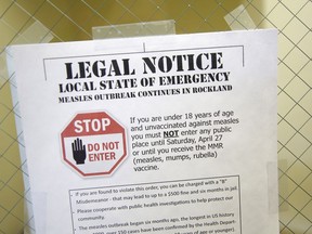FILE - This Wednesday, March 27, 2019 file photo shows a sign explaining the local state of emergency because of a measles outbreak at the Rockland County Health Department in Pomona, N.Y. Measles is spread through the air when an infected person coughs or sneezes. It's so contagious that 90 percent of people who aren't immunized are infected if exposed to the virus, according to the Centers for Disease Control and Prevention.