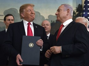 FILE - In this Monday, March 25, 2019 file photo, President Donald Trump smiles at Israeli Prime Minister Benjamin Netanyahu, right, after signing a proclamation in the Diplomatic Reception Room at the White House in Washington. Trump isn't on the ballot for Israel's national election, yet he's a dominant factor for many American Jews as they assess the high stakes of balloting on Tuesday, April 9, 2019.
