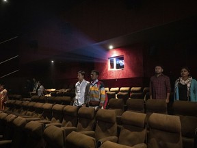 In this Monday, Nov. 26, 2018 photo, moviegoers stand as national anthem is played at a cinema before the screening of a movie in Lucknow, Uttar Pradesh, India. As with similar movements across the world, Hindu nationalism, once fringe, has now taken a central place in India's politics.