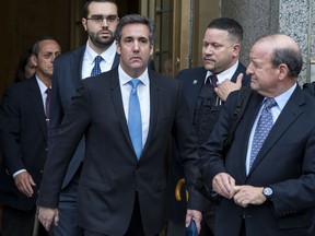 FILE - In this April 16, 2018, file photo, Michael Cohen, President Donald Trump's personal attorney, center, leaves federal court following a hearing in New York. Mueller found some evidence in the redacted report released Thursday, April 18, 2019, that suggests Trump may have intended to discourage Cohen from cooperation. But he reached no conclusion on whether Trump obstructed justice.