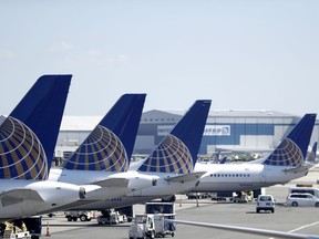 FILE - In this  July 18, 2018, file photo, United Airlines commercial jets sit at a gate at Terminal C of Newark Liberty International Airport in Newark, N.J. The grounding of its Boeing 737 Max jets is causing United Airlines to trim growth plans for this year, and the carrier expects to discuss potential compensation with Boeing.