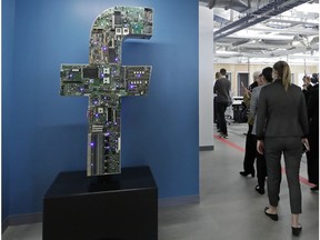 FILE - In this Jan. 9, 2019, file photo, media and guests tour Facebook offices in Cambridge, Mass., building. Facebook says it is rolling out a wide range of updates in order to combat the spread of false and harmful information on the social media site.