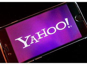 FILE - In this Dec. 15, 2016, file photo, the Yahoo logo appears on a smartphone in Frankfurt, Germany. Nearly 200 million people who had sensitive information snatched from their Yahoo accounts will receive two years of free credit-monitoring services and other potential restitution in a legal settlement valued at $117.5 million. The deal disclosed in documents filed Tuesday, April 9, 2019, revises an earlier agreement struck last October, only to be rejected by U.S. District Court Judge Lucy Koh in San Jose.