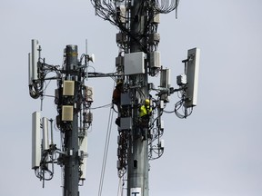 FILE- In this April 17, 2019, file photo workers install equipment on a communications tower in Philadelphia. On Friday, April 26, 2019, the Commerce Department issues the first estimate of how the U.S. economy performed in the January-March quarter.