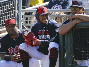 FILE - In this March 18, 2019, file photo, injured Cleveland Indians shortstop Francisco Lindor, center, smiles as he watches his teammates during the first inning of a spring training baseball game against the San Diego Padres in Goodyear, Ariz. Lindor says he's ready to make his season debut after being injured. Lindor sat out Cleveland's first 18 games with a sprained ankle he sustained during spring training in Arizona while recovering from an offseason calf injury. He's expected to be in Cleveland's lineup this weekend against Atlanta.