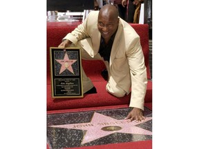 FILE - In this Aug. 26, 2003 file photo, director John Singleton touches his new star on the Hollywood Walk of Fame in Los Angeles. Oscar-nominated filmmaker John Singleton has died at 51, according to statement from his family, Monday, April 29, 2019. He died Monday after suffering a stroke almost two weeks ago.