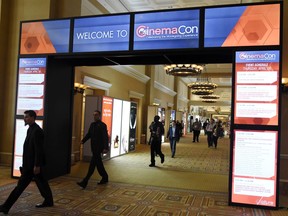 FILE - This April 26, 2018, file photo shows CinemaCon attendees walking through the lobby during CinemaCon 2018 in Las Vegas, the official convention of the National Association of Theatre Owners. The movie industry, everyone from the Hollywood studios that produce the films to the companies that make the screens, speakers and seats in theaters, are descending on Las Vegas this week for CinemaCon.