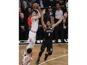 Philadelphia 76ers' JJ Redick, left, shoots over Brooklyn Nets' Spencer Dinwiddie (8) during the first half in Game 3 of a first-round NBA basketball playoff series Thursday, April 18, 2019, in New York.