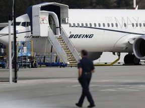FILE - In this March 14, 2019, file photo, a worker walks next to a Boeing 737 MAX 8 airplane parked at Boeing Field in Seattle. U.S. aviation regulators said Monday, April 1, Boeing needs more time to finish changes in a flight-control system suspected of playing a role in two deadly crashes.