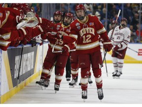 Denver forward Kohen Olischefski (12) celebrates his goal during the first period in the semifinals of the Frozen Four NCAA men's college hockey tournament against Massachusetts on Thursday, April 11, 2019, in Buffalo, N.Y.