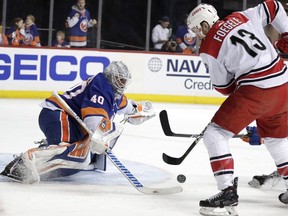 Carolina Hurricanes left wing Warren Foegele (13) attacks New York Islanders goaltender Robin Lehner (40), of Sweden, during the first period of Game 2 of an NHL hockey second-round playoff series, Sunday, April 28, 2019, in New York.