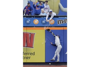 A fan spills beer on Milwaukee Brewers left fielder Ryan Braun as he tries but fails to grab a triple hit by New York Mets' Pete Alonso during the first inning of the MLB baseball game at Citi Field, Sunday, April 28, 2019, in New York.