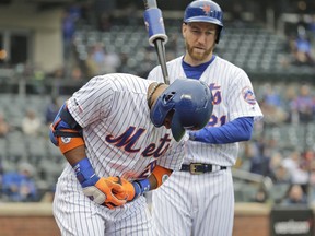 New York Mets' Robinson Cano, left, reacts after being hit by a pitch during the first inning of the MLB baseball game against the Milwaukee Brewers at Citi Field, Sunday, April 28, 2019, in New York.