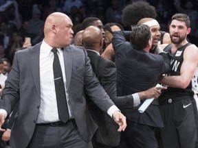 CORRECTS TO SECOND HALF NOT FIRST HALF - Brooklyn Nets head coach Kenny Atkinson, third from right, restrains Nets forward Jared Dudley, second from right, after Dudley got into a shoving match during the second half of Game 4 of a first-round NBA basketball playoff series against the Philadelphia 76ers, Saturday, April 20, 2019, in New York.