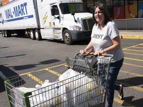 A customer pushes her cart into the parking lot after shopping at a Walmart Neighborhood Market, Wednesday, April 24, 2019, in Levittown, N.Y. The company has made the market into an artificial intelligence lab.