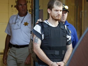 FILE - In this Thursday, Sept. 11, 2014 file photo,Smith County Sheriff Charlie Crumpton, left, watches as Timothy Ray Jones Jr., is escorted by lawmen out of the Smith County Jail to a vehicle for transport to Lexington County, S.C. in Raleigh, Miss. Jury selection is set to begin Monday, April 29, 2019 in the death penalty trial of Jones who police said killed his five young children in their South Carolina home. Authorities say after 37-year-old Timothy Jones Jr. killed his children, ages 8, 7, 6, 2 and 1, in their Lexington home in August 2014, he drove their bodies around for a week, burying them in Alabama and then being arrested in Mississippi. Court records show defense attorneys plan an insanity defense for Jones.