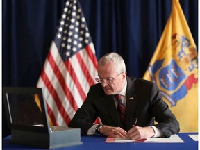 In this photo provided by the New Jersey Office of the Governor, N.J. Gov. Phil Murphy signs the Medical Aid in Dying for the Terminally Ill Act Friday, April 12, 2019 at the New Jersey Statehouse in Trenton, N.J. New Jersey is the seventh state to enact a law permitting terminally ill patients to seek life ending medication. (New Jersey Office of the Governor via AP)