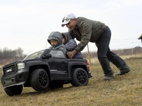 In this Thursday, March 28, 2019 photo, Eladio Beltran, right, pushes his children, Caleb, 4, left, and Jayem, 3, in their car at their home in Albion, N.Y. Beltran faces deportation because he was arrested for driving without a license. In New York and elsewhere, the idea of extending new privileges to those without legal immigration status has been resisted. But a renewed push across the country to allow them to get driver's licenses resonates strongly among those who make their living in the rural crop fields, dairy farms and fruit orchards where the need for everyday transportation can be the greatest.