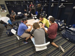 FILE - In this April 8, 2015, file photo, members of the Biloxi Shuckers minor league baseball team eat lunch before practice at the Pensacola Blue Wahoos' stadium in Pensacola, Fla. Minor leaguers at the lowest levels can make as little as $1,100 per month despite spending 50-to-70 hours per week at the ballpark. A lawsuit alleging MLB violated minimum wage and overtime requirements was pre-empted in 2018 when Congress passed the "Save America's Pastime Act," which stripped minor leaguers of the protection of federal minimum wage laws.