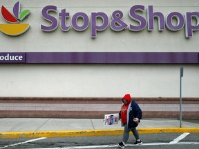 FILE - In this Thursday, April 18, 2019, file photo, a striking worker walks outside a Stop & Shop supermarket in Revere, Mass. Stop & Shop supermarket workers and company officials said Sunday, April 21 they've reached a tentative contract agreement.