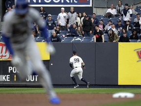 New York Yankees right fielder Aaron Judge (99) fields a ball off the wall hit by Kansas City Royals' Alex Gordon, as Royals' Adalberto Mondesi, left, runs to third base during the first inning of a baseball game, Thursday, April 18, 2019, in New York. Mondesi scored on the play.