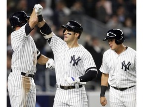 New York Yankees' Brett Gardner, left celebrates with the Mike Tauchman after Tauchman hit a sixth-inning, three-run home run off Boston Red Sox's Erasmo Ramirez during a baseball game Tuesday, April 16, 2019, in New York. Yankees' Gio Urshela, right, scored on the homer, as did Gardner.