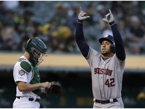 Houston Astros' George Springer, right, celebrates after hitting a home run off Oakland Athletics' Marco Estrada in the first inning of a baseball game, Tuesday, April 16, 2019, in Oakland, Calif.