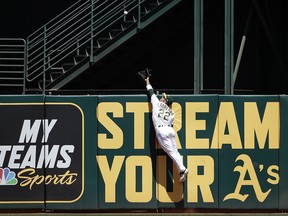 Oakland Athletics center fielder Ramon Laureano jumps to catch a fly ball hit by Toronto Blue Jays' Teoscar Hernandez during the second inning of a baseball game in Oakland, Calif., Sunday, April 21, 2019.