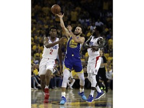 Los Angeles Clippers' Shai Gilgeous-Alexander, left, and Patrick Beverley, right, defend Golden State Warriors' Stephen Curry during the first half in Game 5 of a first-round NBA basketball playoff series, Wednesday, April 24, 2019, in Oakland, Calif.