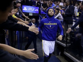 Golden State Warriors' Stephen Curry greets fans as he takes the court for warm up shots prior to an NBA basketball game against the Los Angeles Clippers Sunday, April 7, 2019, in Oakland, Calif.