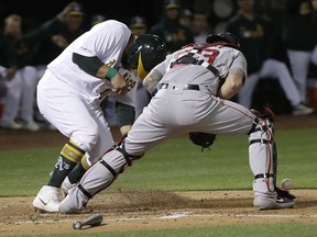 Oakland Athletics' Kendrys Morales, left, scores a run past Boston Red Sox catcher Blake Swihart during the second inning of a baseball game in Oakland, Calif., Wednesday, April 3, 2019.