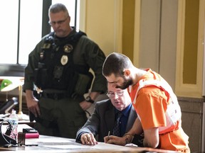 In this Wednesday, April 17, 2019 photo, Case Pigge signs documents in a Scioto County Courtroom in Chillicothe, Ohio. Pigge, a three-time killer already serving life sentences pleaded guilty on Wednesday to attempted aggravated murder and other charges in an attack on an Ohio prison guard and has been sentenced to 32 more years in prison.