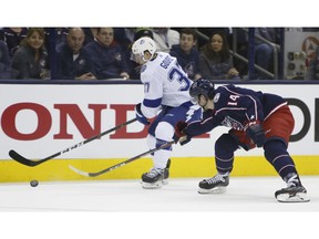 Tampa Bay Lightning's Yanni Gourde, left, carries the puck upice against Columbus Blue Jackets' Dean Kukan, of Switzerland, during the first period of Game 3 of an NHL hockey first-round playoff series Sunday, April 14, 2019, in Columbus, Ohio.