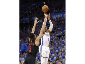 Oklahoma City Thunder guard Russell Westbrook (0) shoots a three point basket as Portland Trail Blazers guard CJ McCollum (3) defends in the first half of Game 4 of an NBA basketball first-round playoff series Sunday, April 21, 2019, in Oklahoma City.