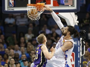 Oklahoma City Thunder center Steven Adams (12) dunks in front of Los Angeles Lakers center Moritz Wagner, left in the first half of an NBA basketball game Tuesday, April 2, 2019, in Oklahoma City.