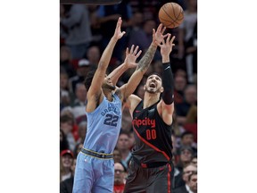Portland Trail Blazers center Enes Kanter, right, and Memphis Grizzlies guard Tyler Dorsey vie for a rebound during the first half of an NBA basketball game in Portland, Ore., Wednesday, April 3, 2019.