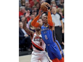 Oklahoma City Thunder guard Russell Westbrook, right, shoots next to Portland Trail Blazers guard Damian Lillard during the first half of Game 2 of an NBA basketball first-round playoff series Tuesday, April 16, 2019, in Portland, Ore.