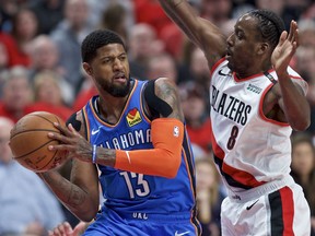 Oklahoma City Thunder forward Paul George, left, looks to pass the ball around Portland Trail Blazers forward Al-Farouq Aminu during the first half of Game 2 of an NBA basketball first-round playoff series Tuesday, April 16, 2019, in Portland, Ore.