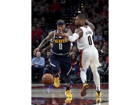 Denver Nuggets guard Isaiah Thomas, left, knocks the ball away from Portland Trail Blazers guard Damian Lillard during the first half of an NBA basketball game in Portland, Ore., Sunday, April 7, 2019.