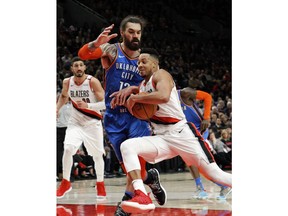 Portland Trail Blazers guard CJ McCollum, right, drives against Oklahoma City Thunder center Steven Adams, front left, during the second half of Game 1 of a first-round NBA basketball playoff series in Portland, Ore., Sunday, April 14, 2019.