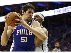 Philadelphia 76ers' Boban Marjanovic, left, of Serbia, makes a move against Brooklyn Nets' Jared Dudley, right, during the first half in Game 1 of a first-round NBA basketball playoff series, Saturday, April 13, 2019, in Philadelphia.