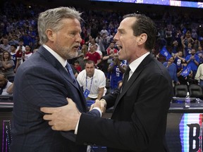 Philadelphia 76ers head coach Brett Brown, left, talks with Brooklyn Nets head coach Kenny Atkinson, right, following Game 5 of a first-round NBA basketball playoff series, Tuesday, April 23, 2019, in Philadelphia. The 76ers won 122-100.