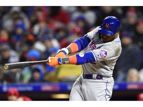 New York Mets' Robinson Cano follows through after hitting a two-run double off Philadelphia Phillies' Aaron Nola during the fourth inning of a baseball game, Monday, April 15, 2019, in Philadelphia.
