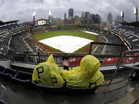 Fans sit in the stands at PNC Park in hopes of the tarp coming off the field, during a rain delay before a baseball game between the Pittsburgh Pirates and the San Francisco Giants in Pittsburgh, Friday, April 19, 2019.