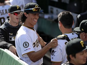 Pittsburgh Pirates' shortstop Cole Tuckert, center, walks through the dugout before taking the field for his first major league baseball game against the San Francisco Giants in Pittsburgh, Saturday, April 20, 2019.
